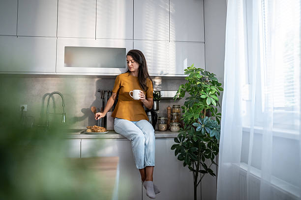istock Woman enjoying coffee and breakfast in sunlit kitchen 2241975596