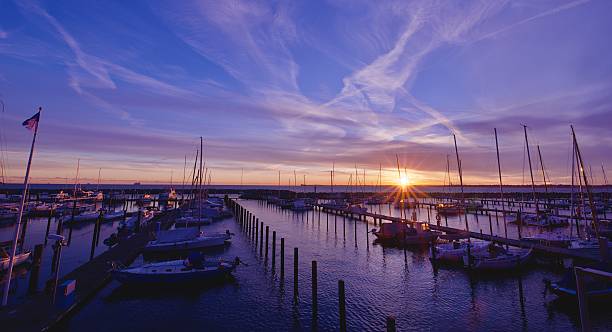 istock Sunrise over a calm harbor with boats 2241976231