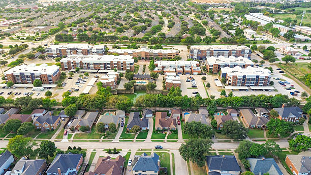 istock Three-layer dense housing layers in Highland Village, Texas with upscale homes pools in foreground, white-roof apartment buildings mid-frame, and suburban grid in background, residential zoning 2241976437