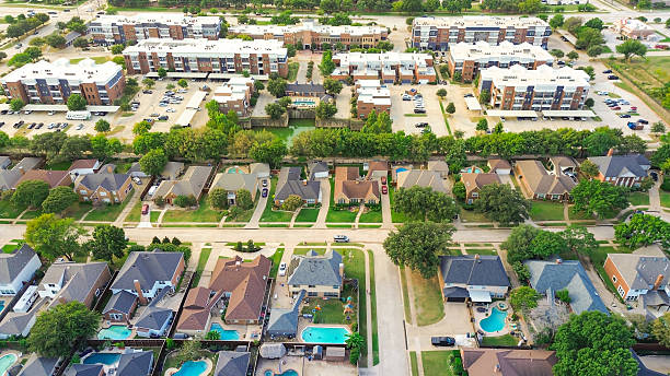 istock Upscale single-family homes with backyard pools adjacent to modern apartment complex, separated by thick tree wall buffer in Highland Village, illustrating zoning transition, privacy planning 2241976440