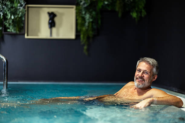 istock Smiling man relaxing in hot tub at spa 2241980230