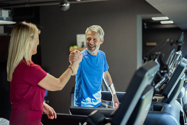 istock Senior couple giving high five on gym treadmill 2241980628