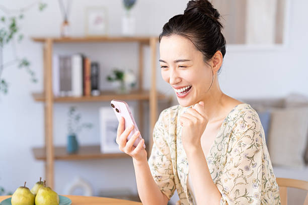 istock Young woman looking at smartphone at home 2241982927