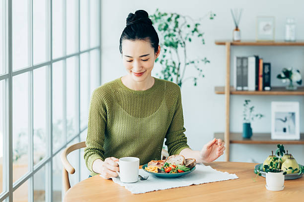 istock Young woman eating breakfast at home 2241984816