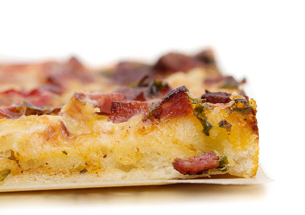 Slice of delicious american pizza with sausages and tomatoes. Isolated on a white background.