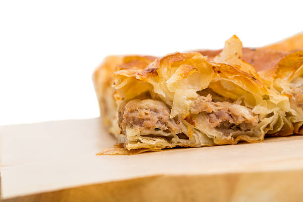 A piece of meat is cooked and has a crispy crust. It is cut into small pieces and is sitting in a baking tray