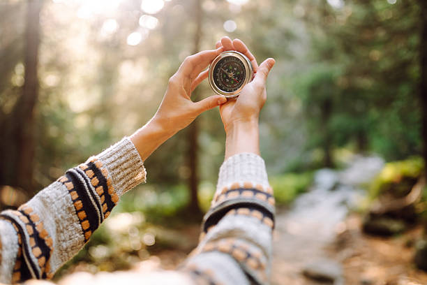 istock Female hiker with backpack holds compass on rocky hiking trail. 2241986343