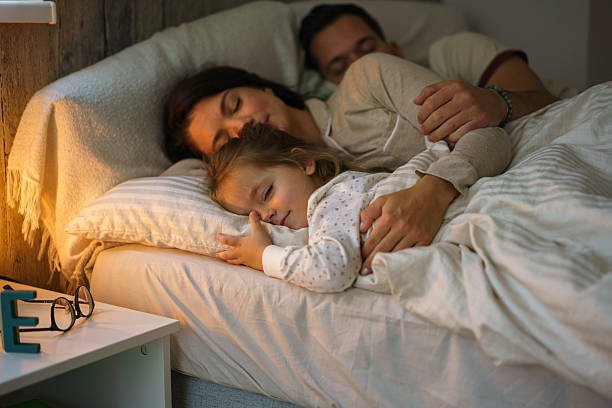 istock Parents and child enjoying sleeping in bed 2241988996