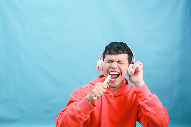 istock Energetic Man Singing with Toothbrush and Headphones. 2241989196