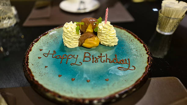 istock Birthday dessert plate with whipped cream and chocolate decoration on table 2241995175