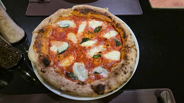 Margherita pizza with fresh mozzarella and basil on white plate in restaurant