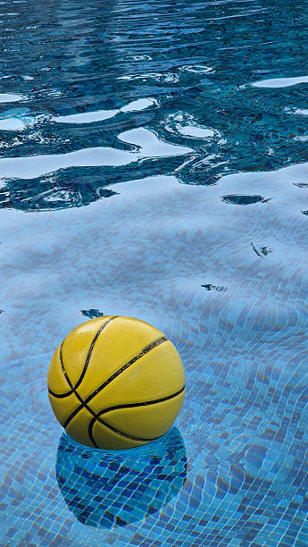 istock Yellow basketball floating on water surface in swimming pool 2241995185