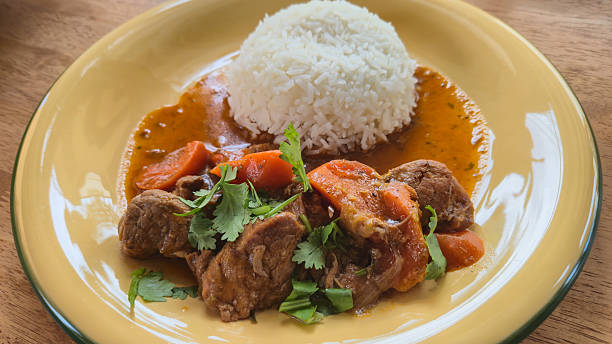 istock Beef stew with carrots and cilantro served with white rice on plate 2241995352