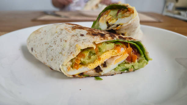 istock Vegetarian wrap sandwich with fresh vegetables and avocado on white plate 2241995377