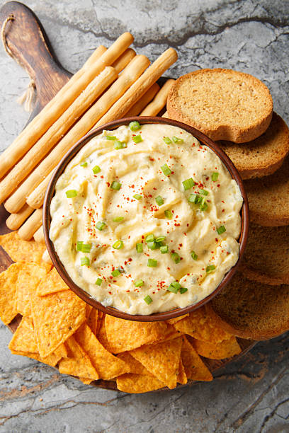 istock Tasty Deviled Egg Dip with nachos, breadsticks, and toast close-up in a plate. Vertical top view 2242000250