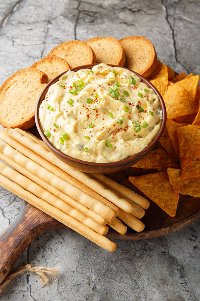 istock Tasty Deviled Egg Dip with nachos, breadsticks, and toast close-up in a plate. Vertical 2242000257