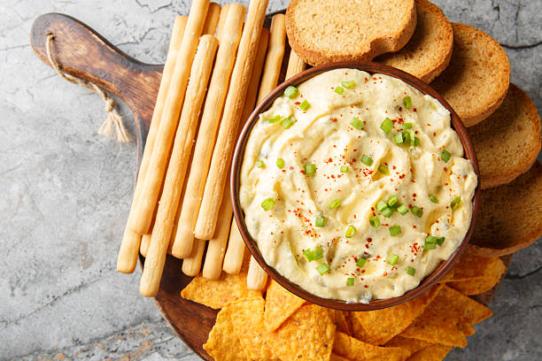 istock Homemade Deviled Egg Dip sauce with chips, breadsticks and biscuit close-up in a plate. Horizontal top view 2242000387