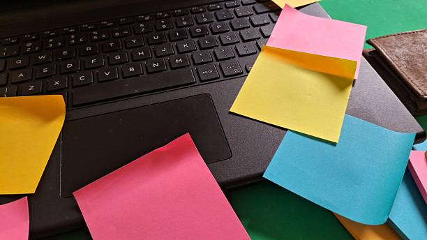 istock Colorful sticky notes scattered across a laptop keyboard and desk 2242001404