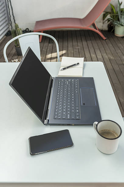 istock A small metal terrace table painted in plain blue, with a laptop open on top along with a cup of coffee, a smartphone and a notepad 2242002929