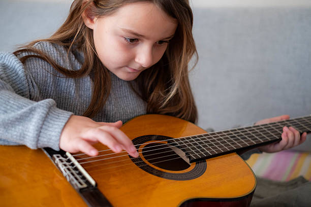 istock Girl child learning acoustic guitar practicing music hobby 2242003946