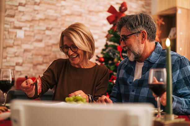 istock Senior couple celebrating christmas dinner with wine and laughter 2242006003