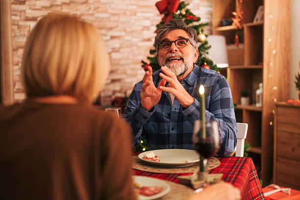 istock Senior man talking during christmas dinner celebration with partner 2242007322