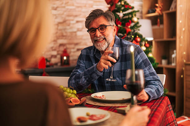 istock Mature man smiling and enjoying christmas dinner with wine 2242008128