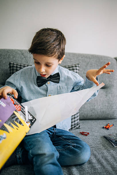 istock Joyful Kid Unwrapping Birthday Present at Home 2242009300