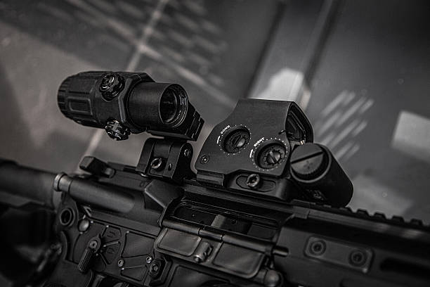 istock A close-up in black and white of a tactical rifle's receiver with red dot sight and flashlight attachment. 2242010105