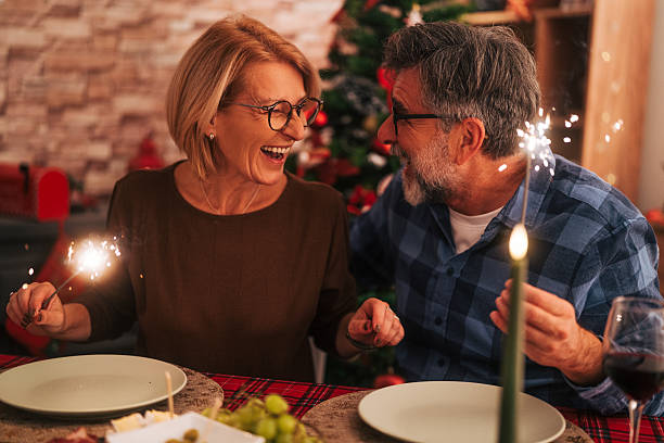 istock Mature couple celebrating holidays with sparklers at dinner 2242011911