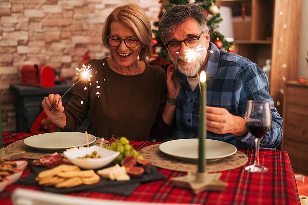 istock Senior couple celebrating holiday dinner with sparklers 2242012339