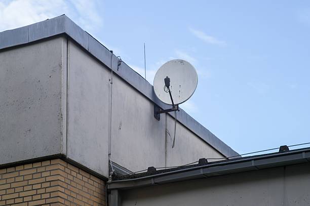 istock Satellite dish on building wall receiving communication signal 2242016446