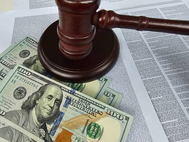istock Court decision document with hundred dollar bills and a gavel on top emphasizing legal 2242018107