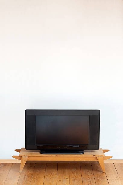 istock An Older television on a wooden table on a white wall background 2242019823