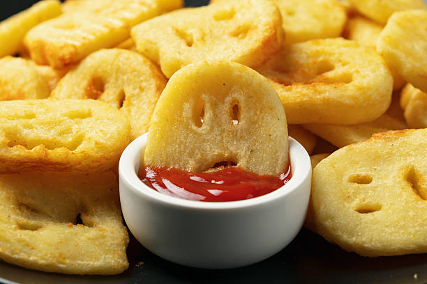 Fried Halloween potato shapes on black plate