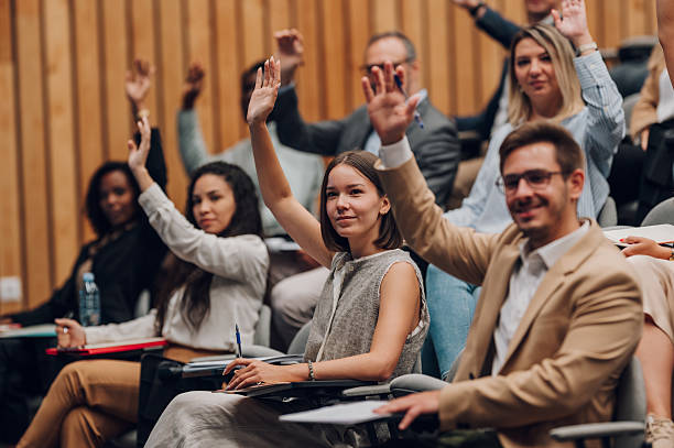 istock Audience raising hands participating in a seminar or conference 2242027323