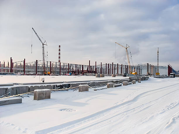 Construction site in winter with cranes and snow