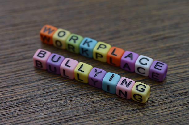 istock The phrase WORKPLACE BULLYING. the active steps required to block and eliminate destructive behavior in the workplace. 2242031355