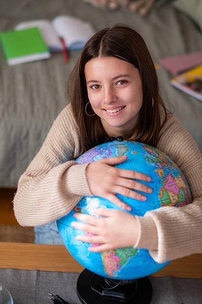 istock Teen girl hugging globe learning geography smiling 2242031702