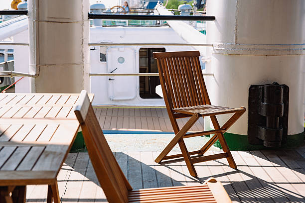 istock Wooden Chair And Table On Sunlit Ship Deck 2242031747