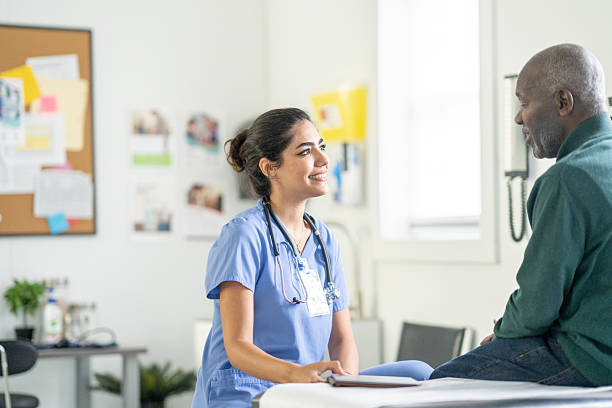 istock Caring Hispanic Nurse In Blue Scrubs Talks With Smiling Patient In Modern Clinic Setting 2242033805
