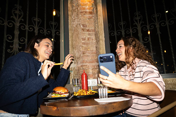 istock Young friends laughing and posing for a user-generated content selfie during a casual dinner at a bar 2242038927