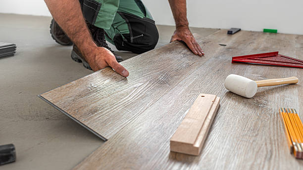 istock Floating floor work. The worker inserts the board of vinyl plank to the click system of Floating floor. 2242041109