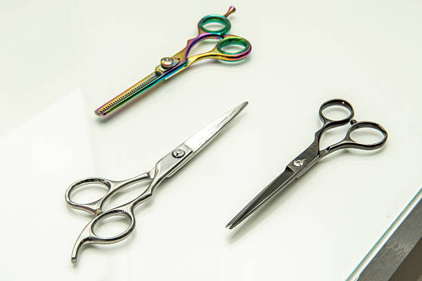 istock Various types of barber scissors on a white wooden surface 2242041501
