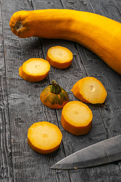 Freshly Sliced Yellow Squash on Rustic Wooden Table with Knife for Farm-to-Table Cooking Concepts