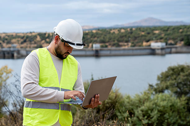 istock Engineer collecting data on laptop, standing next to a dam, managing water infrastructure for energy regulation 2242047671