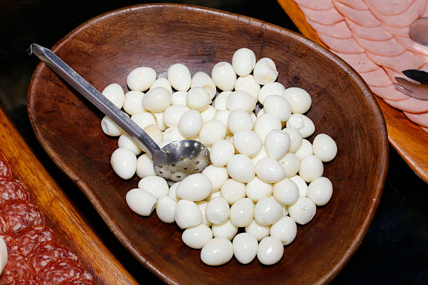 Boiled peeled quail eggs in rustic wooden bowl