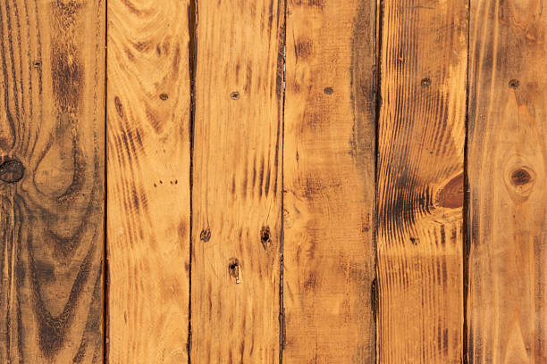 Brown distressed rustic wood grain with twig imperfections and scratches. Overhead view of old dark brown wooden table. Texture or abstract background. Place for text.
