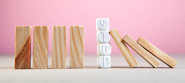 istock Wooden blocks with the word STOP on a pink background 2242058974