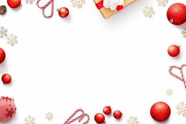 White background with Christmas decorations. Frame of red baubles, candy canes, gift and snowflakes top view